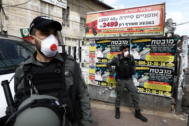 شرطيان إسرائيليان يضعان كمامتين في القدس. تصوير: عمار عوض - رويترز.